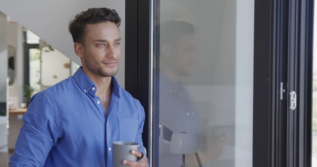 Smiling Man in Blue Shirt Holding Mug at Home - Download Free Stock Images Pikwizard.com