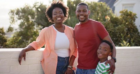 Smiling african american family enjoying golden hour on suburban rooftop terrace