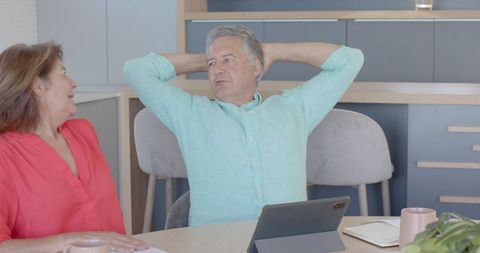 Senior Couple Relaxing at Home with Tablet on Table