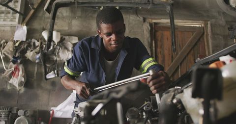 Dedicated mechanic repairing car in rural workshop