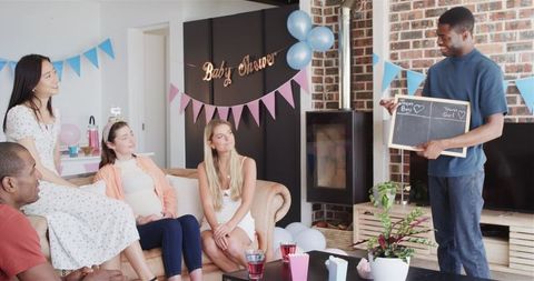 Diverse Friends Enjoying Baby Shower Games in Bright Living Room