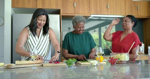 Multigenerational african american women preparing lunch together in modern kitchen