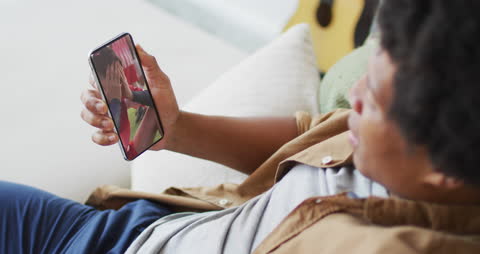 Man Watching Soccer Players on Smartphone at Home Comfortably