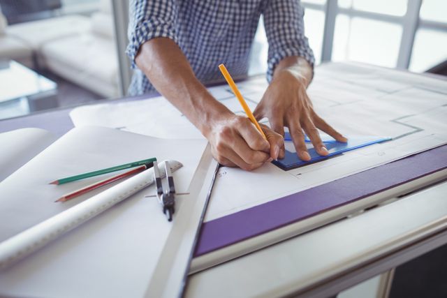Interior designer drawing diagrams on paper in office. Hands using pencil and ruler to create precise plans. Ideal for content related to architecture, design, creativity, professional workspaces, and planning.