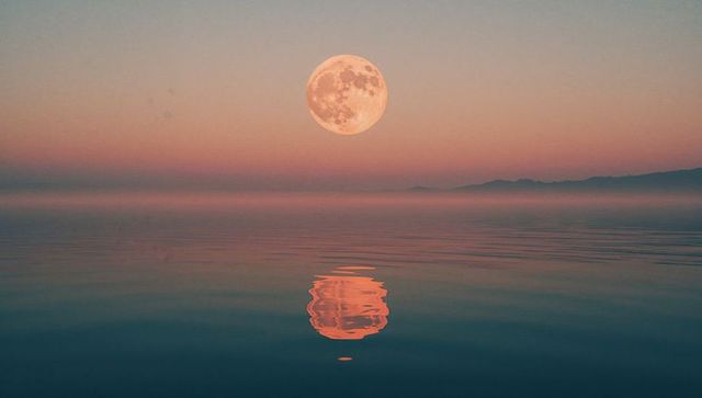 Full Moon Reflection Over Calm Sea During Twilight