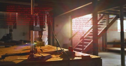 Benchtop drill press boring perforated wood block producing shavings in sunlit workshop