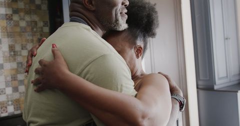 Happy Senior African American Couple Embracing in Kitchen
