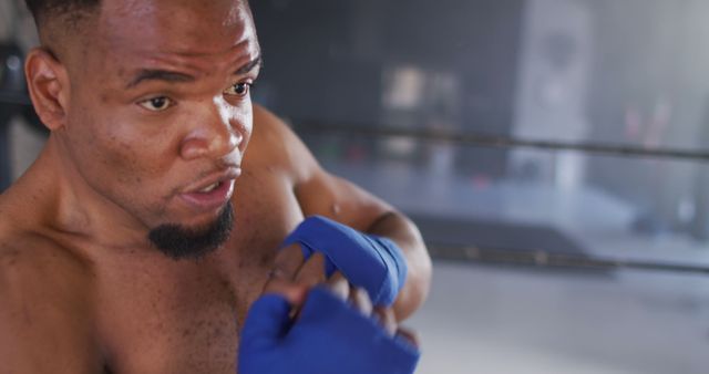 Image of fit african american man boxing at gym. active, fit, sporty and healthy lifestyle, exercising at gym concept.