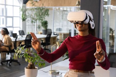 Businesswoman Wearing VR Headset Interacting with Virtual Interface in Modern Office