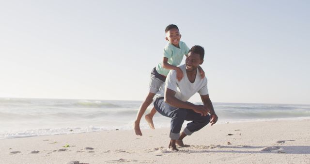 Father and son spending an enjoyable, playful time together on a sunny beach. They are dressed casually, radiating happiness and togetherness. Perfect for themes of family bonding, outdoor leisure, summer vacations, and positive lifestyle moments. Can be used in promotions for family vacations, parenting blogs, and lifestyle websites.