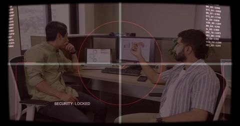 Two colleagues reviewing data at cubicle with security overlay and dashboard charts