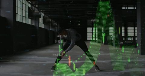 Male athlete stretching in industrial warehouse with green data overlay