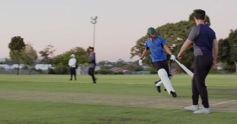 Teenage batsman sprinting to crease playing shot while teammate receiving return throw