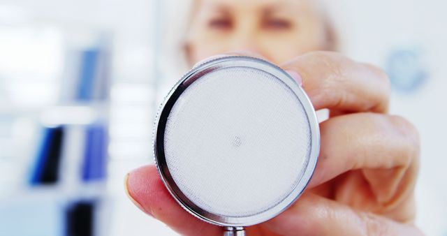 Close-up view of a doctor holding a stethoscope in a medical office. This can be used in healthcare marketing, medical websites, health blogs, and informational content regarding medical examinations or healthcare professionals.