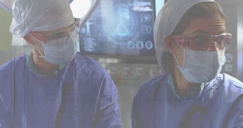Female Surgeons Analyzing Scans in Operating Room Setting