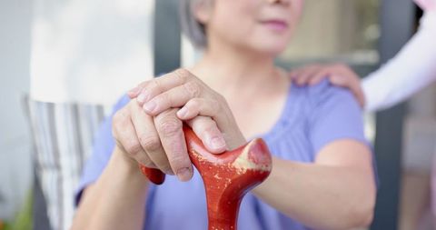 Elderly woman receiving support for mobility challenges