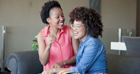 Happy Couple Laughing Together on Comfortable Sofa