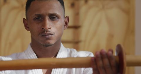 Focused martial artist training with judo jo in gym