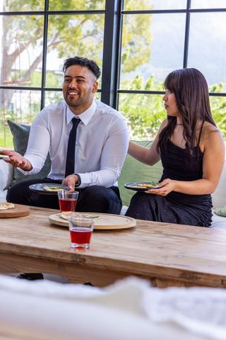Diverse couple sharing plated appetizers in elegant lounge wearing formal attire
