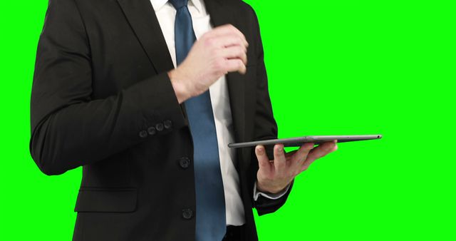 Businessman using his digital tablet on green screen 
