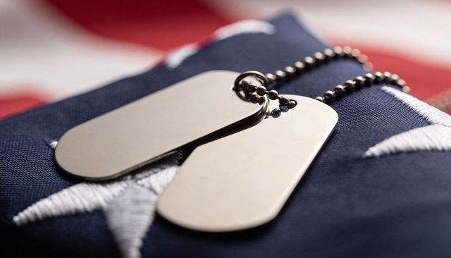 Stainless dog tags resting on folded us flag, commemorating military service and sacrifice
