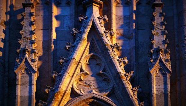 Gothic gable with quatrefoil tracery and crocketed finials in warm golden light