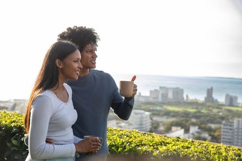 Couple Enjoying Scenic City View with Morning Coffee
