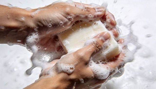 Hands lathering soap bar with foamy bubbles close-up hygiene cleansing minimalist