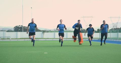 Team of Male Athletes Practicing on Hockey Field