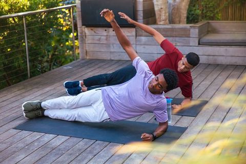 African American Friends Exercising Outdoors with Side Plank Pose