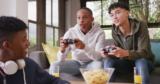 Teenage friends sitting on a couch in a living room, engaging in an exciting video game session, showcasing fun and bonding over technology. This can be used for illustrating themes of youth friendships, leisure activities, home entertainment, and social interactions.