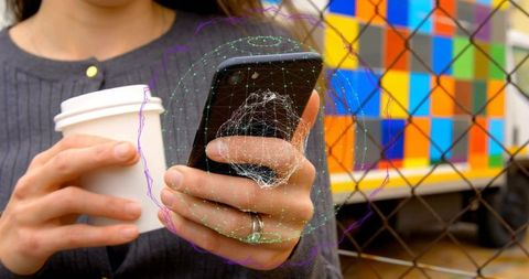 Woman tapping smartphone while holding coffee cup, activating augmented reality data grid