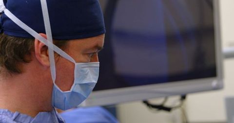 Veterinary surgeon focused during horse operation in theater setting