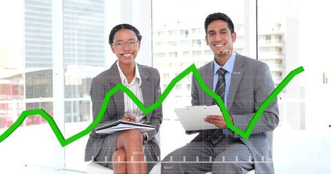 Smiling business executives analyzing green growth chart on tablet in modern city office