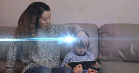 Asian Mother and Son Enjoying Tablet Magic on Couch