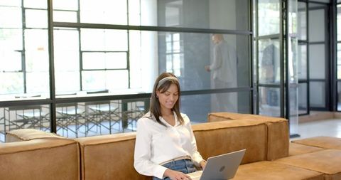 Businesswoman Using Laptop on Couch in Modern Office - Download Free Stock Images Pikwizard.com
