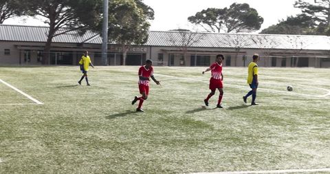 Youth soccer players competing on school football pitch
