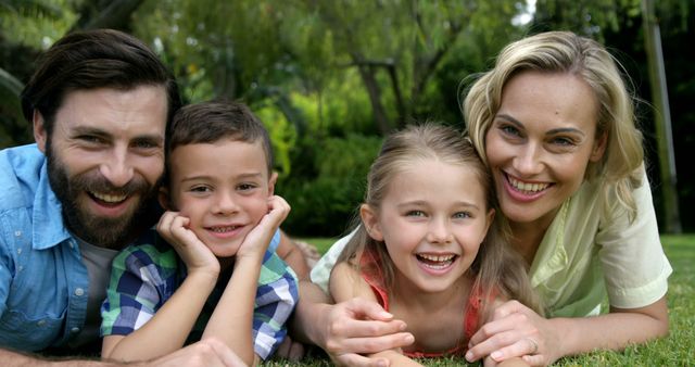 Happy Family Lying on Grass in Park Smiling at Camera - Download Free Stock Images Pikwizard.com