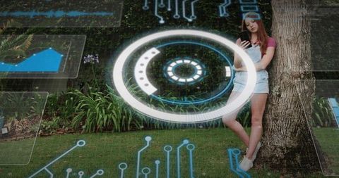 Young woman leaning on tree using smartphone with futuristic augmented reality hud overlay