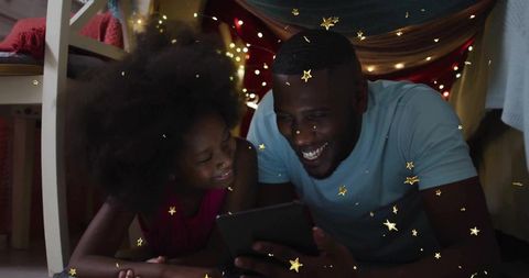 Father and Daughter Watching Tablet in Magical Blanket Fort