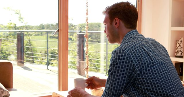 Young Man Enjoying Morning Coffee by Large Window - Download Free Stock Images Pikwizard.com