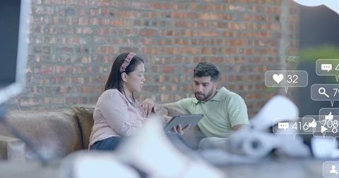 Colleagues Collaborating Using Digital Tablet in Modern Lounge