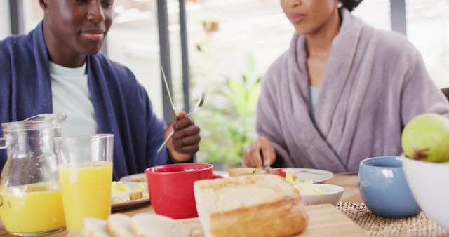 Image of happy african american couple drinking juice together. Love, relationship and spending quality time together concept.