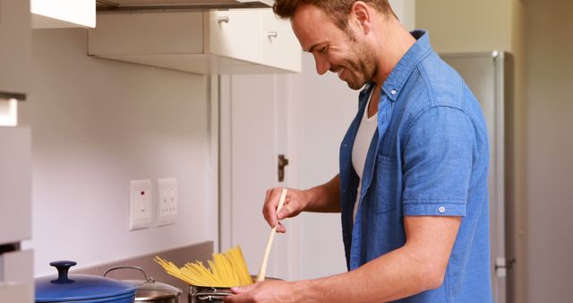 Man Cooking Spaghetti in Modern Kitchen Setting - Download Free Stock Images Pikwizard.com