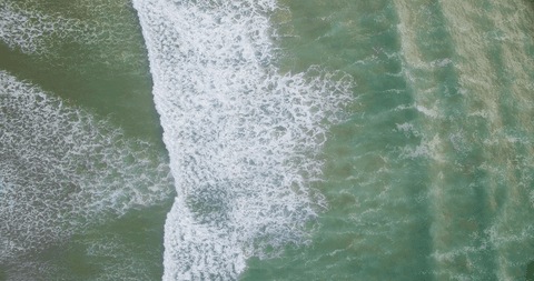 aerial view of transparent ocean waves crashing on shoreline - Download Free Stock Videos Pikwizard.com