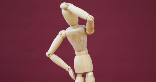 A wooden artist's mannequin is posed as if it's looking into the distance, with copy space. Its pose suggests contemplation or searching, adding a creative touch to the simple composition.