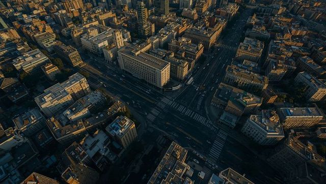 Aerial golden hour view showing downtown intersection capturing urban grid and rooftops