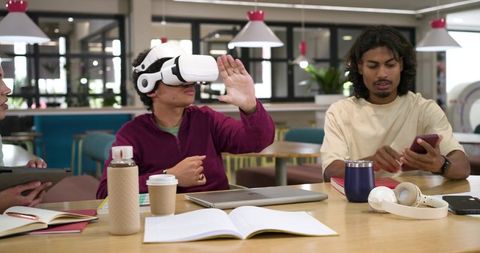 African students collaborating in campus study lounge using VR headset and mobile devices