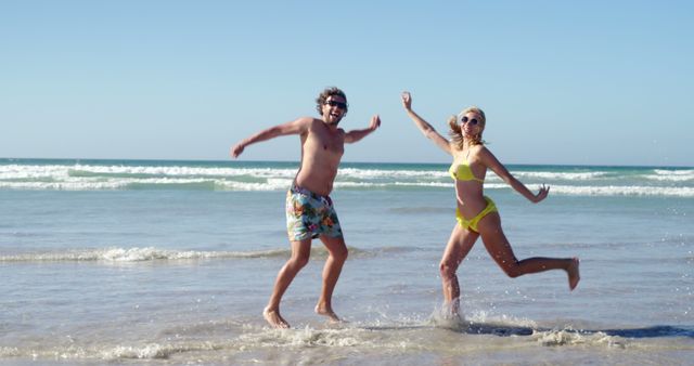 Happy Couple Jumping Enjoying Sunny Day at Beach - Download Free Stock Images Pikwizard.com