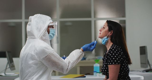 Medical worker in protective clothing taking swab test from female patient. healthcare, medical research technology and hygiene during coronavirus covid 19 pandemic.